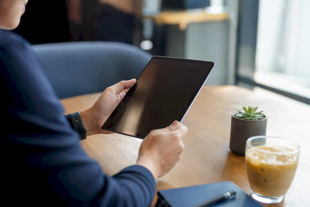 Hands holding tablet reviewing resume preview
