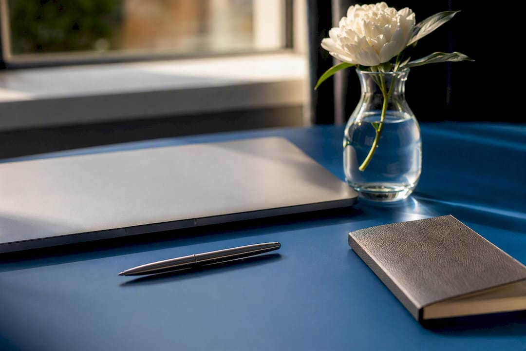 Pen and glasses on desk near blank tablet